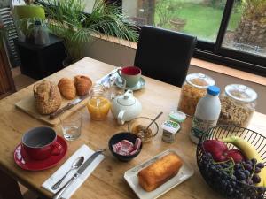 a wooden table with breakfast food on it at Villa plaisance in Plomodiern
