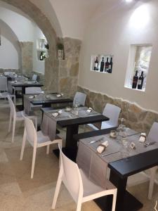 ein Restaurant mit Tischen, Stühlen und Weinflaschen in der Unterkunft Affittacamere Le Isole in Trapani
