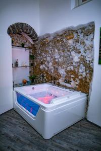 una vasca idromassaggio in una camera con parete in pietra di Salerno Mare e Luci Deluxe a Salerno