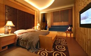 1 dormitorio con 1 cama y TV de pantalla plana en Spring Young Motel, en Fengyuan