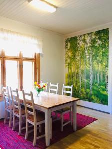 a dining room table with chairs and a painting on the wall at Tiinala in Mikkeli