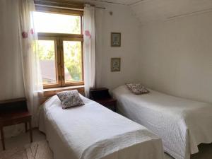 two beds in a room with a window at Tiinala in Mikkeli