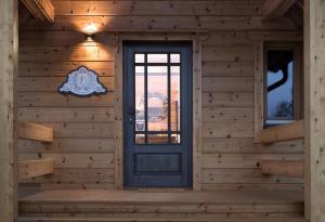 une maison en bois avec une porte bleue et des fenêtres dans l'établissement Rezidencia Woodchalet, à Veľká Lomnica