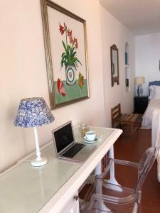 a desk with a laptop and a lamp on it at La Bergerie Isolabella sea view B & B in Taormina