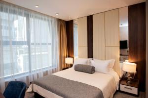a hotel room with a bed and a large window at Family Hotel Business Club in Shumen