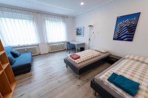 腓特烈港Stadthaus Seeblick G5 - Hostel的一间卧室，配有一张床、一张沙发和一张书桌