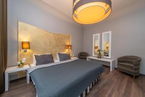 ein Schlafzimmer mit einem großen Bett mit einer blauen Decke in der Unterkunft Emporio Prague Apartments in Prag