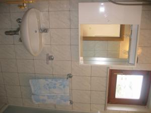 La salle de bains est pourvue d'un lavabo et d'un miroir. dans l'établissement Apartments Zafranović, à Prvić Luka