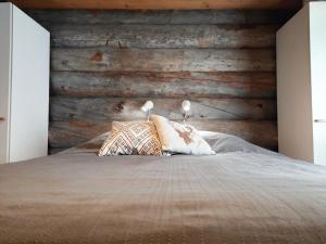 a bedroom with a bed with a wooden wall at Riemula cabin in Kuusamo