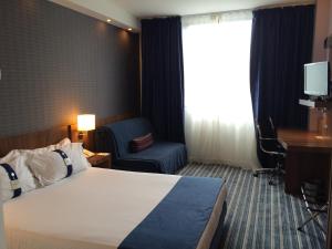 Habitación de hotel con cama, silla y escritorio. en Holiday Inn Express Bilbao Airport, an IHG Hotel en Derio