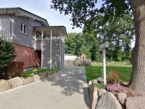 a house with a tree and a driveway at Strohböhn in Oldendorf