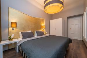 a bedroom with a large bed with a blue comforter at Emporio Prague Apartments in Prague