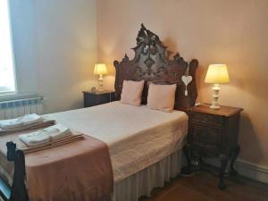 a bedroom with a large bed with a wooden headboard at Vila Delfina in Lousã