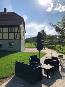 un patio con tavolo, sedie e ombrellone di Ferienwohnung Bömitz a Rubkow