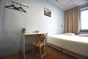 1 dormitorio con 1 cama y escritorio con silla en ID Hostel Rostov-on-Don, en Rostov-on-Don