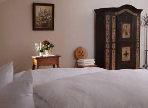 1 dormitorio con cama blanca y armario de madera en Hotel Restaurant Café Rapp, en Königsfeld im Schwarzwald
