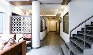 een gang van een gebouw met trappen en stoelen bij Hotel Seven in Chandīgarh