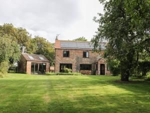 an old brick house with a large grass yard at Craven Cottage in Great Driffield