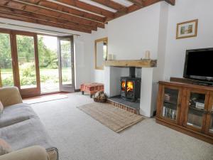 a living room with a fireplace and a tv at Craven Cottage in Great Driffield