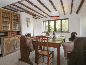 uma sala de jantar com uma mesa de madeira e cadeiras em Craven Cottage em Great Driffield