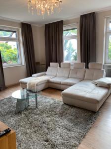 a living room with a white couch and a glass table at Landhotel Traube in Baden-Baden