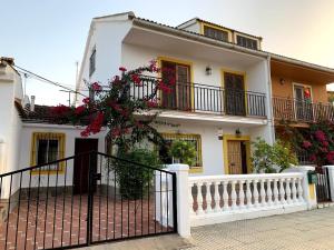 uma casa branca com varanda e flores em Antigua Estación de Campanillas em Málaga