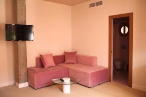 sala de estar con sofá rosa y mesa en APARTAMENTOS Los Patios de San Agustín, en Córdoba