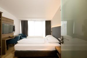 ein Hotelzimmer mit 2 Betten und einem Fenster in der Unterkunft Das Jedermann Boutiquehotel mit Stadtgarten in Salzburg