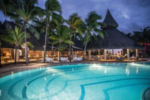 - une piscine bordée de palmiers et un complexe dans l'établissement Shandrani Beachcomber Resort & Spa, à Blue Bay