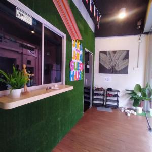 a room with a green wall with a window at JOKA-JOKA GUESTHOUSE in Malacca