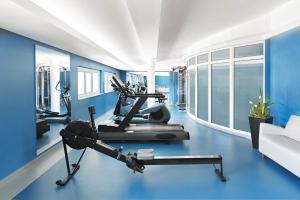 a room with a gym with blue walls and a treadmill at Hotel Europa Fit Hévíz in Hévíz
