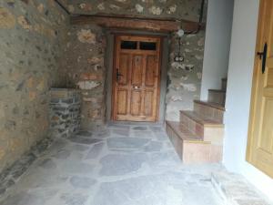 a hallway with a wooden door in a stone wall at Casa Purujosa in Purujosa +29 photos
