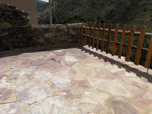 a patio with a wooden fence and a stone floor at Casa Purujosa in Purujosa