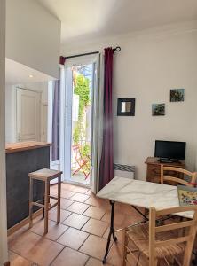 een woonkamer met een tafel en een televisie bij Anne de la Maison Blanche in Avignon