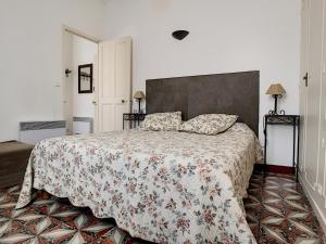 een slaapkamer met een bed met een bloemenbed bij Anne de la Maison Blanche in Avignon