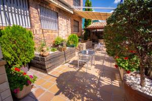 a patio with a table and chairs and plants at Hostal El Cruce in Paracuellos de Jarama