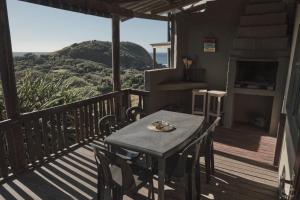 a table and chairs on a deck with a view at BlueCottage or Seaview Cottage at Coram Deo Lodge self catering in Coffee Bay