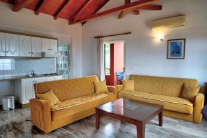 a living room with two couches and a coffee table at Magda Hotel Apartments in Ancient Epidavros