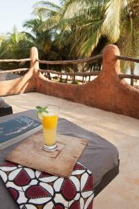 a glass of orange juice sitting on a table at Tama Lodge in Mbour