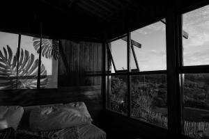 Zimmer mit einem Bett und einem großen Fenster in der Unterkunft BlueCottage or Seaview Cottage at Coram Deo Lodge self catering in Coffee Bay