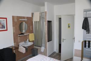 ein Bad mit einem Waschbecken und einem Spiegel in der Unterkunft Gasthof Post in Rothenburg ob der Tauber