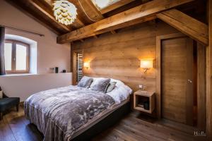 een slaapkamer met een bed en een houten muur bij Le Moulin duplex sous les toits à la Princesse Demi-Quartier in Demi-Quartier