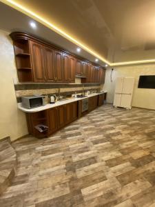a large kitchen with wooden cabinets and a tile floor at cozy apartments in Truskavets +12 photos