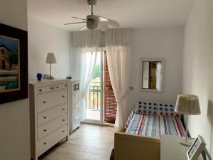 a bedroom with a bed and a dresser and a window at Antigua Estación de Campanillas in Málaga