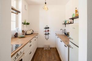 a kitchen with white cabinets and a wooden counter top at Boardinghouse alte Spinnerei in Offenburg