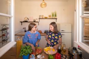 dwie dziewczyny stojące w kuchni przygotowujące jedzenie w obiekcie Boardinghouse alte Spinnerei w mieście Offenburg