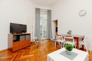 a living room with a dining table and a television at ShortStayPoland Klonowa (B29) in Warsaw