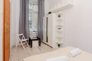 a white room with a bed and a chair at ShortStayPoland Klonowa (B29) in Warsaw
