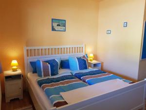 a small bedroom with a bed with blue pillows at Pension An der Erzgebirgsbahn in Kurort Oberwiesenthal