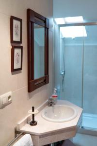 een badkamer met een wastafel en een glazen douche bij Ático con vistas al mar in A Guarda